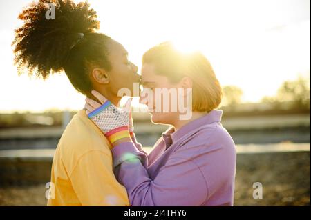 Felice coppia gay baciare nel parco Foto Stock