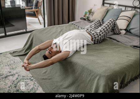 Un uomo che si trova sul letto e che ha un aspetto rilassato Foto Stock