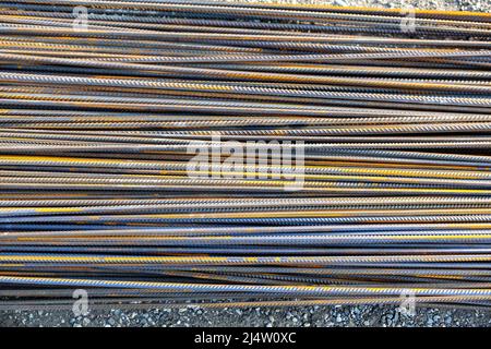 Pila di aste o barre di ferro arrugginite. Vecchia asta di metallo arrugginita o di acciaio. Molto rebar è nel magazzino per la costruzione. Foto Stock