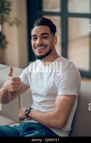 Il giovane si sente bene dopo la vaccinazione con il covid-19 Foto Stock