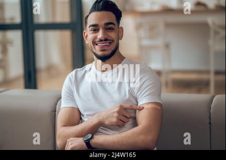 Il giovane si sente bene dopo la vaccinazione con il covid-19 Foto Stock