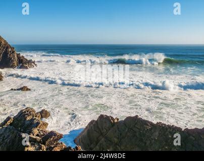 Onde grandi e pericolose che si propagano in una costa rocciosa Foto Stock