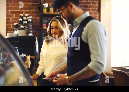 Bell'uomo e bella donna che sceglie dolci e torte in caffetteria. Uomo attraente che acquista i dessert alla caffetteria. Cliente maschio che sceglie i biscotti a. Foto Stock