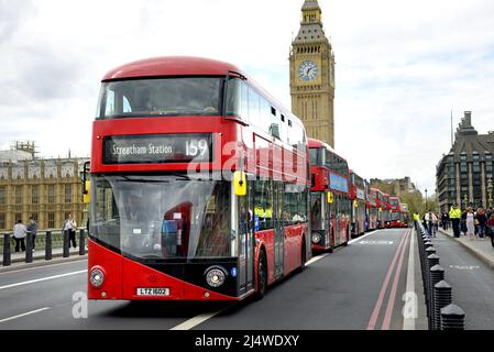 Londra, Inghilterra, Regno Unito. Lunga fila di autobus a due piani sul Ponte di Westminster, lentamente dopo una marcia di protesta da Extinction Rebellion, aprile 2022 Foto Stock