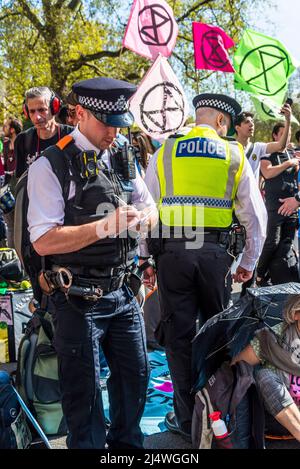 La polizia incontrata che si impegna con i manifestanti su strada bloccati da un sit-in a non saremo spettatori, una protesta della ribellione di estinzione che combatte per il clima Foto Stock