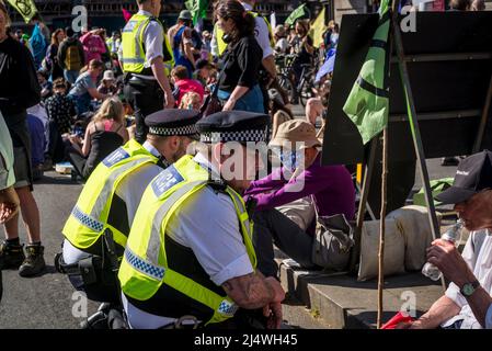 La polizia incontrata che si impegna con i manifestanti su strada bloccati da un sit-in a non saremo spettatori, una protesta della ribellione di estinzione che combatte per il clima Foto Stock