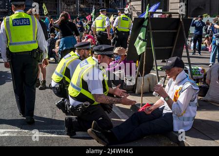 La polizia incontrata che si impegna con i manifestanti su strada bloccati da un sit-in a non saremo spettatori, una protesta della ribellione di estinzione che combatte per il clima Foto Stock