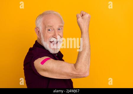 Profilo lato foto di uomo anziano celebrare trionfo muscoli vaccinati protezione isolato su sfondo giallo Foto Stock