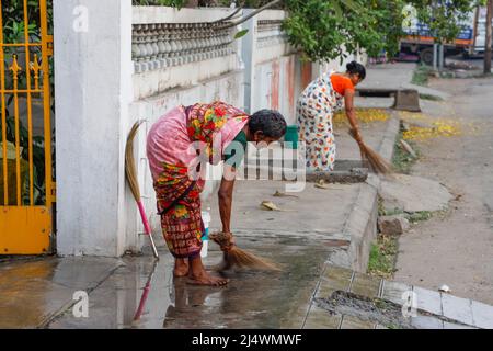 Le donne puliscono il viale di accesso la mattina presto a Trichy, Tamil Nadu, India Foto Stock