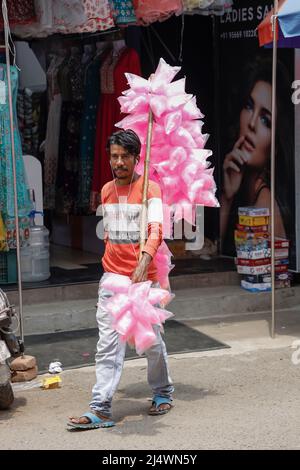 Un giovane uomo che cammina per strada vendendo caramelle di cotone a Trichy, Tamil Nadu, India Foto Stock