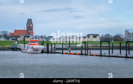 Cuxhaven, Germania - 02.25.2022: Panorama della città con la barriera verde alluvione nel porto di Cuxhaven in prima mattina d'inverno Foto Stock