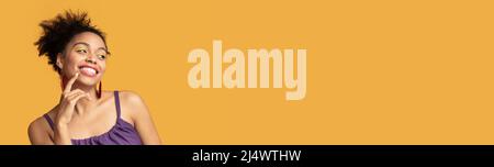 Curioso Black Woman guardando da parte Copia spazio con eccitazione, banner largo Foto Stock