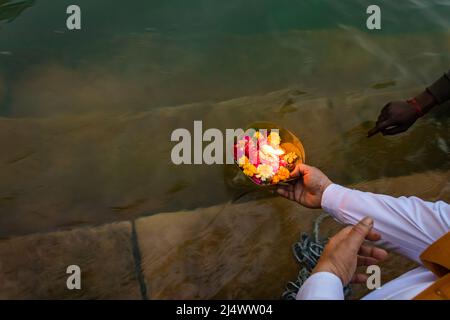 il devotee offre fiori al fiume santo al mattino dall'angolo superiore Foto Stock
