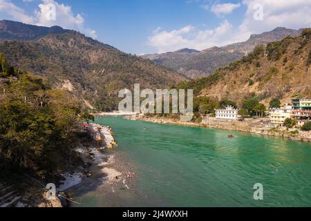 il fiume ganges che scorre attraverso le montagne con la città annidata a riva del fiume dall'immagine dell'angolo superiore è preso a rishikesh uttrakhand india il 15 2022 marzo. Foto Stock