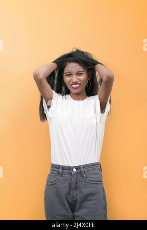 Donna in stress.Indian sud asiatico donna stressata sta andando pazzo tirando i suoi capelli in frustrazione e fare il viso. Foto Stock