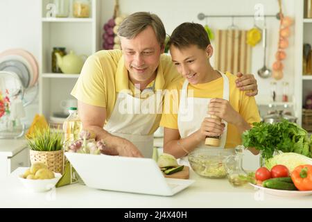Ritratto di uomo e ragazzo la cottura in cucina Foto Stock