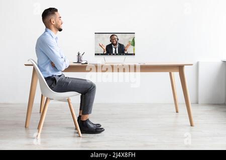 Uomo arabo che usa un computer portatile per videochiamare e parlare Foto Stock