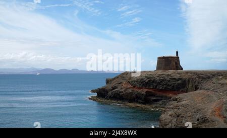 Vecchio Forte napolionico sulla cima della scogliera a Playa Blanca Lanzarote Spagna con ciclista cosa a bordo. Foto Stock