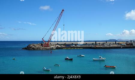 Lavori in corso di ampliamento del porto di Playa Blanca con gru. Foto Stock