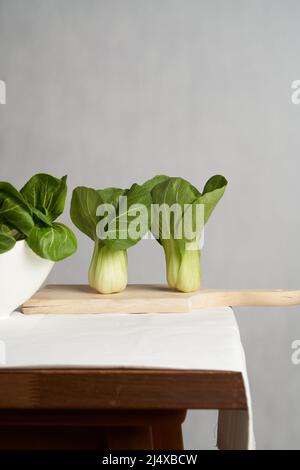 Fresco Bok Choy o Pak Choy, cavolo cinese su un tavolo rustico in legno. Verdura verde biologica, scena cucina. Tema sano stile di vita. Foto Stock