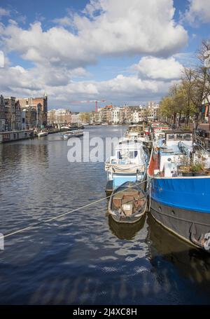 case galleggianti e chiatte ormeggiate lungo uno dei molti canali e corsi d'acqua di amsterdam olanda Foto Stock