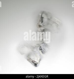 Sfuocatura astratta del movimento di una confezione blister per pillole in alluminio e plastica su sfondo grigio chiaro, concetto per la salute e tossicodipendenza Foto Stock