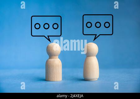 Bambole di legno con chiacchierata di bolla di discorso. Interazione e concetto di chat Foto Stock