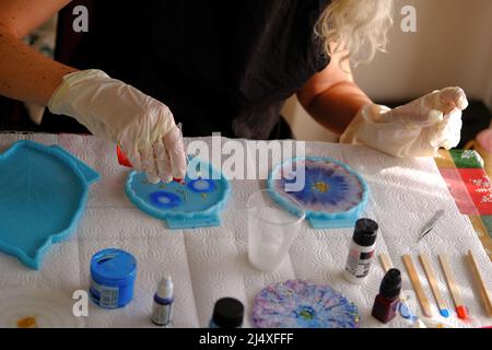 Donna che fa arti e mestieri di resina epossidica. Foto Stock