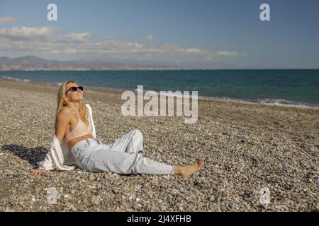 Signora vivace godendo l'estate su una spiaggia vuota durante la vacanza Foto Stock