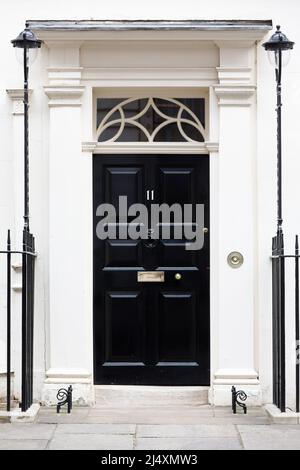 La famosa porta nera al numero 11 Downing Street, tradizionalmente la casa del Cancelliere dello scacchiere, Westminster, Londra, Regno Unito Foto Stock