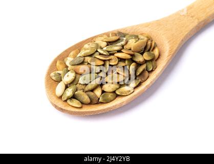 Semi di zucca in un cucchiaio isolato su sfondo bianco. Foto Stock
