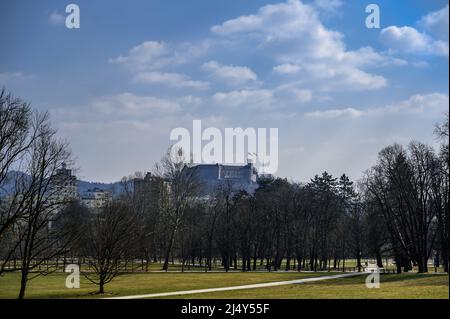 Alberi del Parco Tivoli di Lubiana con il castello sullo sfondo in una giornata di sole Foto Stock