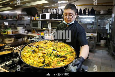 Palma, Spagna. 18th Apr 2022. Richard, chef del ristorante 'Sa Pressa' con cucina tipica maiorchina, cuoca la paella tradizionale prima di aprire per i clienti l'ultimo giorno delle celebrazioni di Pasqua. Credit: Clara Margais/dpa/Alamy Live News Foto Stock