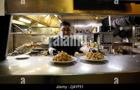 Palma, Spagna. 18th Apr 2022. Richard, chef del ristorante 'Sa Prema' con cucina tipica maiorchina, serve una tapa fritta con polpo l'ultimo giorno delle vacanze pasquali. Credit: Clara Margais/dpa/Alamy Live News Foto Stock