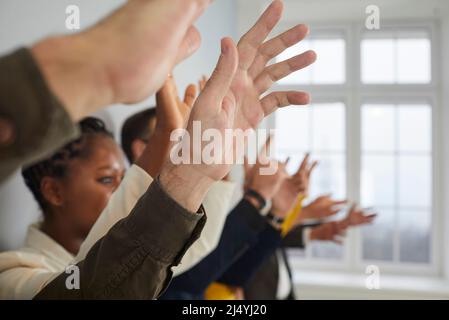 Diverse folle di persone che alzano le mani per fare domande alla conferenza pubblica Foto Stock