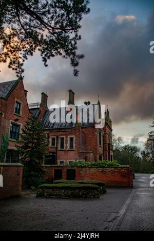 Il grado II* ha elencato Abney Hall su un giorno umido e tempestoso a Cheadle, Greater Manchester, Regno Unito. Foto Stock