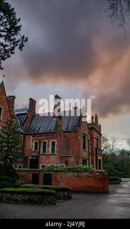 Il grado II* ha elencato Abney Hall su un giorno umido e tempestoso a Cheadle, Greater Manchester, Regno Unito. Foto Stock