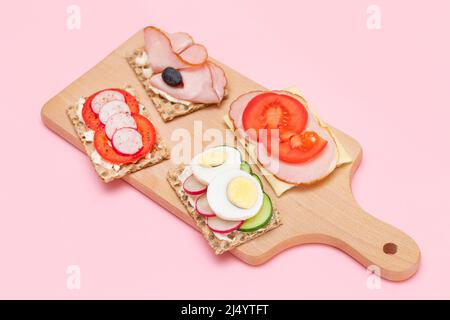 Diversi tipi di pane integrale con Prato, pomodoro, Rasth, cetriolo e formaggio. Colazione facile. Dieta alimentare. Panini veloci e sani. Croccante con gustoso ripieno. Snack dietetico sano Foto Stock