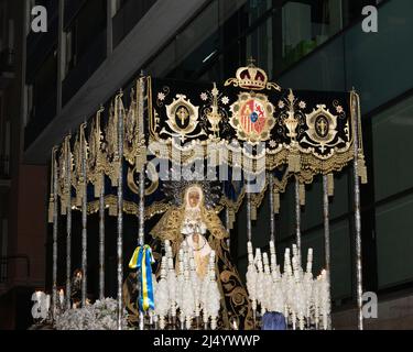 Virgen Maria in processione ad Alicante alla settimana Santa , candele un trono con bandiera Ucraina Foto Stock