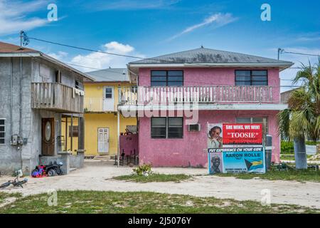 Cartelli elettorali all'esterno di case a due piani a Bimini, le Bahamas. Foto Stock