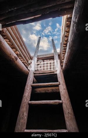 Una scala di legno conduce dalla ricostruzione di un Kiva indiano Pueblo dei nativi americani al Pecos National Historical Park nel New Mexico. Foto Stock