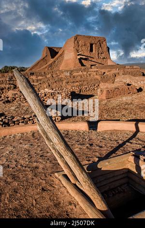 Una ricostruzione dei nativi americani di Kiva con le rovine della Chiesa Missionaria Spagnola presso il Pecos National Historical Park nel New Mexico. Foto Stock