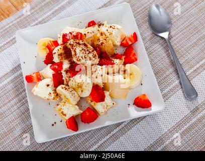 Gelato con fragole tritate e banane servito al tavolo Foto Stock