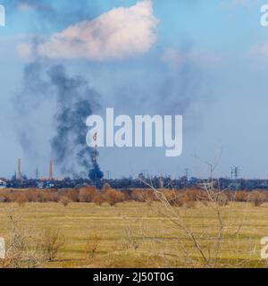 Fumo da un incendio nella distanza dietro il campo Foto Stock