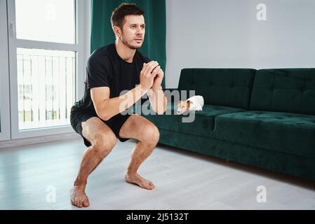 Uomo che fa esercizi sportivi a casa, allenamento sportivo a casa, concetto di stile di vita Helathy Foto Stock