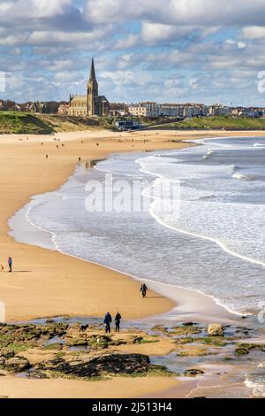 Spiaggia di Long Sands a Tynemouth in una giornata di primavera, con la chiesa di St George a Cullercoats in lontananza, Tyne and Wear, Inghilterra, Regno Unito Foto Stock