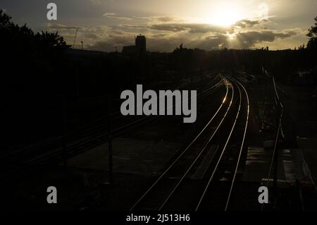 Luce serale riflessa dai binari del treno Kentish Town Road, Kentish Town, Londra, Regno Unito. 10 maggio 2014 Foto Stock