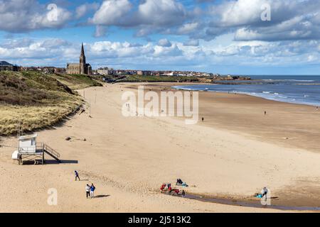 Spiaggia di Long Sands a Tynemouth in una giornata di primavera, con la chiesa di St George a Cullercoats in lontananza, Tyne and Wear, Inghilterra, Regno Unito Foto Stock