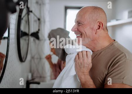 Coppia anziana in bagno, viso di lavaggio, concetto di routine del mattino. Foto Stock