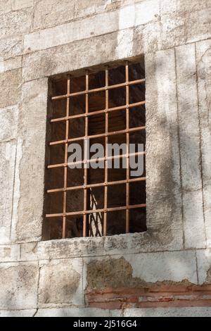 Antico traliccio forgiato su finestra in parete spessa. Foto Stock